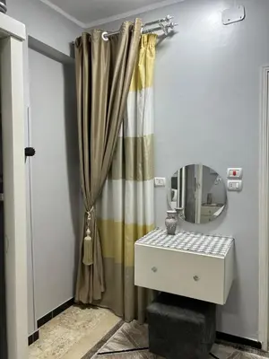 a bathroom with a shower curtain and a mirror at Oscar Apartment 9 in Luxor