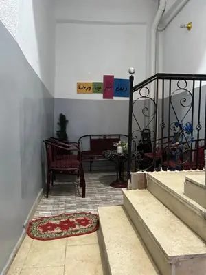 a porch with two chairs and a table and a rug at Oscar Apartment 9 in Luxor
