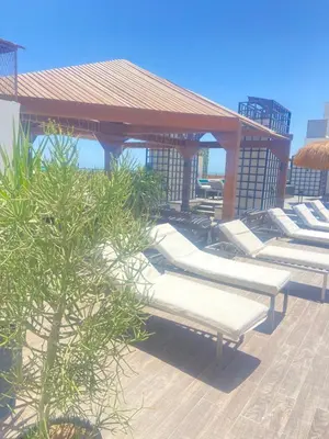 a group of white benches sitting under a gazebo at Studio Imperial resort pool view in Hurghada