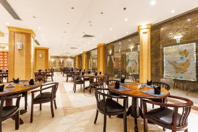 a dining room with wooden tables and chairs at Sunrise Solara Aqua park Resort in Banī Ghālib