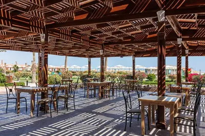 a group of tables and chairs under a pavilion at Sunrise Solara Aqua park Resort in Banī Ghālib