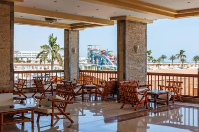 a restaurant with tables and chairs and a water park at Sunrise Solara Aqua park Resort in Banī Ghālib