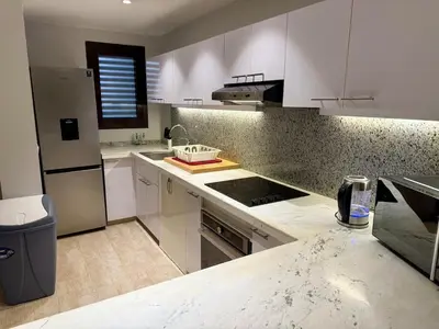 a kitchen with white cabinets and a counter top at Picturesque 3BR Villa- Free Lagoon Access ElGouna in Hurghada