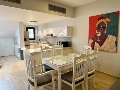 a kitchen with a table and chairs and a painting at Picturesque 3BR Villa- Free Lagoon Access ElGouna in Hurghada