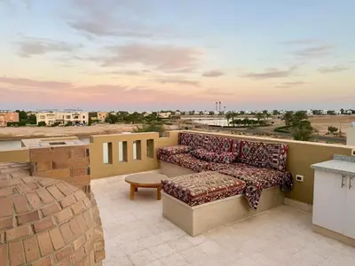a couch on a balcony with a view of a city at Picturesque 3BR Villa- Free Lagoon Access ElGouna in Hurghada