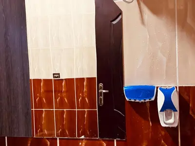 a door to a bathroom with tiles on the wall at Prestige Home apartment in Hurghada