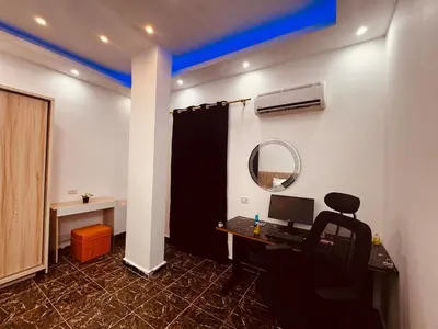 an office with a desk with a computer and a mirror at Prestige Home apartment in Hurghada