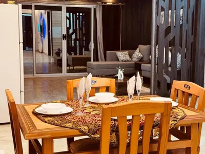 a dining room table and chairs with a table and chairsktop at Prestige Home apartment in Hurghada