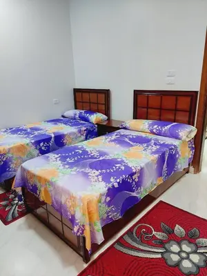 a room with three beds with colorful sheets at Wohnung in Al Ahyaa Hurghada in Hurghada