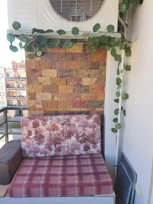 a bench in front of a brick wall with plants at Tiba golden resort in Hurghada