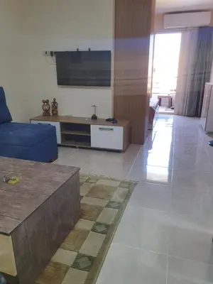 a living room with a blue couch and a tv at Tiba golden resort in Hurghada