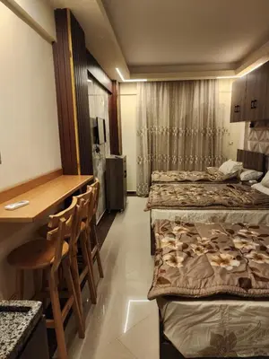 a room with three beds and a table and chairs at Cecilia Village in Hurghada