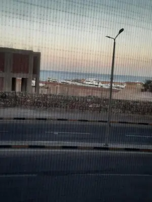 a street light next to a beach with a building at Sea view holidays in Hurghada