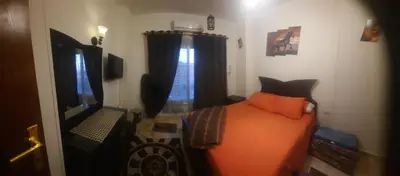 a bedroom with an orange bed and a television at Sea view holidays in Hurghada