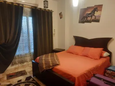 a bedroom with a bed and a window with a horse picture at Sea view holidays in Hurghada