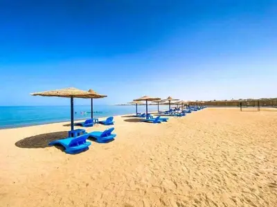 a row of umbrellas and chairs on a beach at Cecilia Village in Hurghada