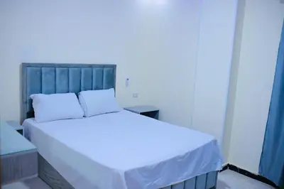 a bedroom with a large bed with white sheets at رويال بالاس in Hurghada
