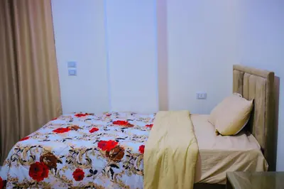a bed with a floral comforter in a bedroom at رويال بالاس in Hurghada