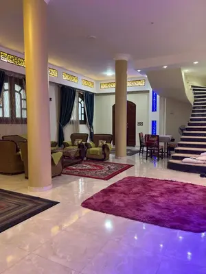a lobby with a staircase and a purple rug at Family House in Luxor