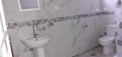 a white bathroom with a sink and a toilet at منزل عبد الرحيم العمدة in Luxor