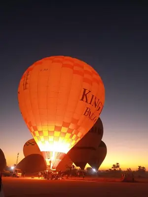 a group of hot air balloons in the sky at night at White Rose House in Luxor
