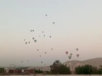a bunch of hot air balloons in the sky at White Rose House in Luxor