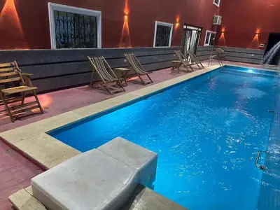 a large swimming pool with chairs and a table at Royal palace in Hurghada