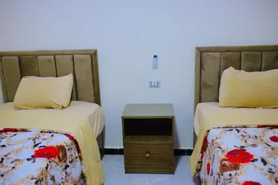 a room with two beds and a table between them at Royal palace in Hurghada