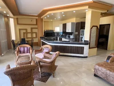 a lobby with wicker chairs and a bar with a kitchen at Apartment with sea view in Hurghada