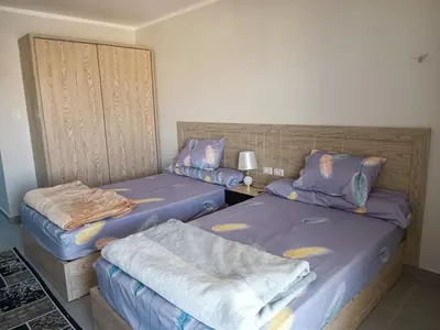 two beds in a room with two bedsskirts at Sunset View at scandic Beach WIFI in Hurghada