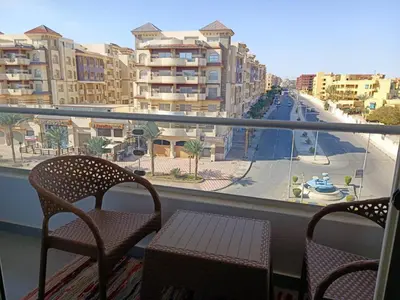 a balcony with chairs and a view of a street at Sunset View at scandic Beach WIFI in Hurghada