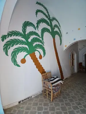 a mural of a palm tree on a wall at Mashamman nuban house in Aswan