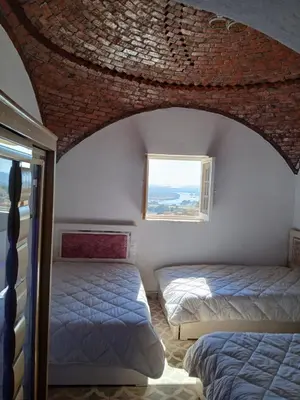 a bedroom with two beds and a window at Mashamman nuban house in Aswan