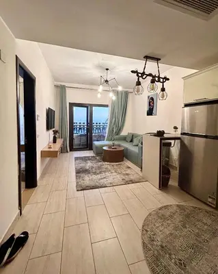 a living room with a blue couch and a kitchen at Hurghada Escape Pool and Sea View in Hurghada