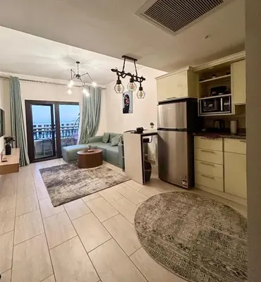 a kitchen and living room with a couch and a refrigerator at Hurghada Escape Pool and Sea View in Hurghada