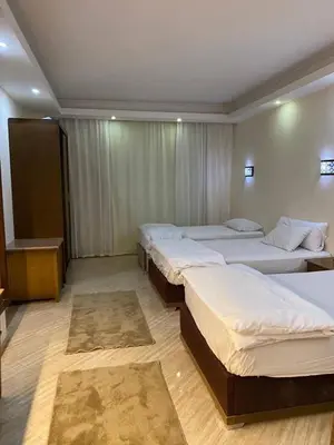 a room with three beds and a table in it at سيسليا بيتش ريزورت in Hurghada