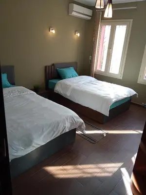 two beds in a room with a window at , كمبواند قمريه in Hurghada