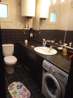 a bathroom with a toilet sink and a washing machine at , كمبواند قمريه in Hurghada