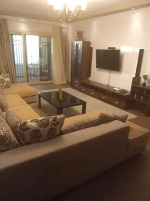 a living room with a couch and a flat screen tv at , كمبواند قمريه in Hurghada