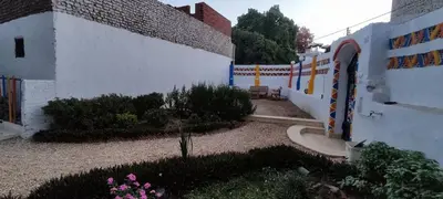 a courtyard of a building with a fence and flowers at Kemet Guest House in Aswan
