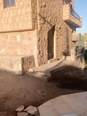 a stone building with a door and a balcony at Al Agamay Nile view guest House in Jazīrat Aswān