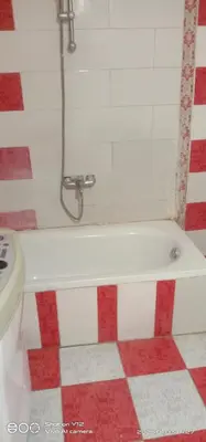 a bath tub in a bathroom with red and white tiles at Al Agamay Nile view guest House in Jazīrat Aswān