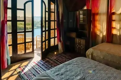 a bedroom with a bed and a large window at Moon of Nuba House in Aswan