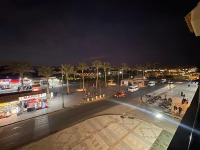 a city street at night with cars and lights at Relaxing apartment in Hurghada