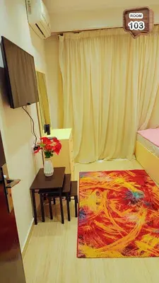 a room with a table with a vase of flowers on it at Relaxing apartment in Hurghada