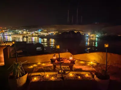 a table with lights on a balcony at night at Nala Narty Nubian House & Organic Farm in Aswan