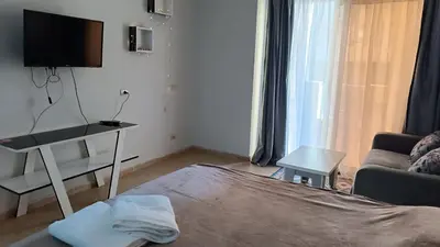 a living room with a couch and a tv at Cozy studio Florenza Khamsin in Hurghada