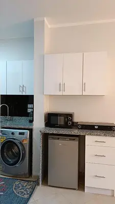 a kitchen with a washing machine and a microwave at Cozy studio Florenza Khamsin in Hurghada