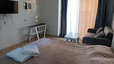 a bedroom with a bed and a couch and a table at Cozy studio Florenza Khamsin in Hurghada