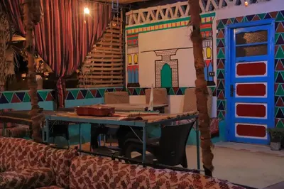 a room with a stage with a table and a staircase at Carmah Nubian Guesthouse in Aswan